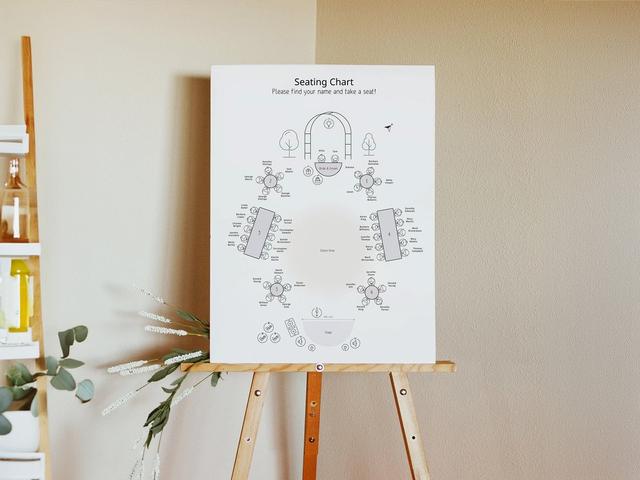 Simplifiez l'organisation de votre mariage grâce à notre élégant plan de table ! Présenté sur un élégant chevalet en bois, ce plan aide les invités à trouver facilement leur place grâce à des étiquettes claires et faciles à lire. Il présente un mélange de tables rondes et rectangulaires, toutes méticuleusement numérotées et entourées de noms d'invités personnalisés. Le plan met également en évidence des zones essentielles telles que la table des mariés, l'espace de danse et la scène.