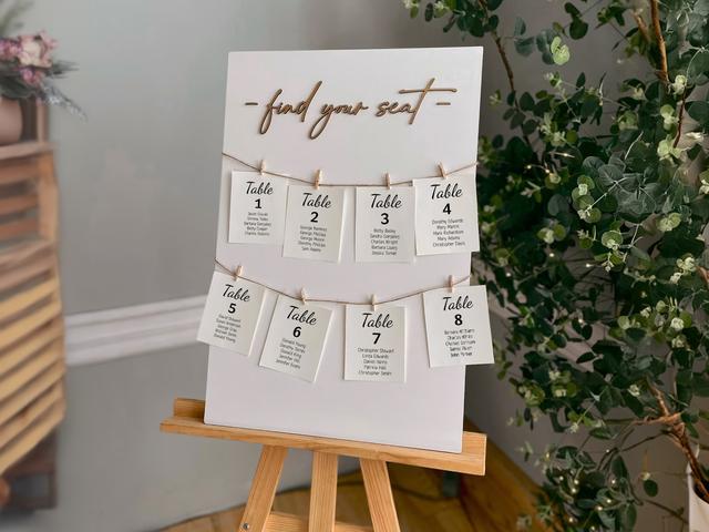 Elevate your event decor with this elegant seating chart display. Featuring a stylish “find your seat” sign, this setup combines chic minimalism with functional beauty. Perfect for weddings or formal gatherings, it guides your guests effortlessly to their assigned tables. Decorated with charming hanging cards and natural greenery, it’s the perfect addition to a memorable celebration!