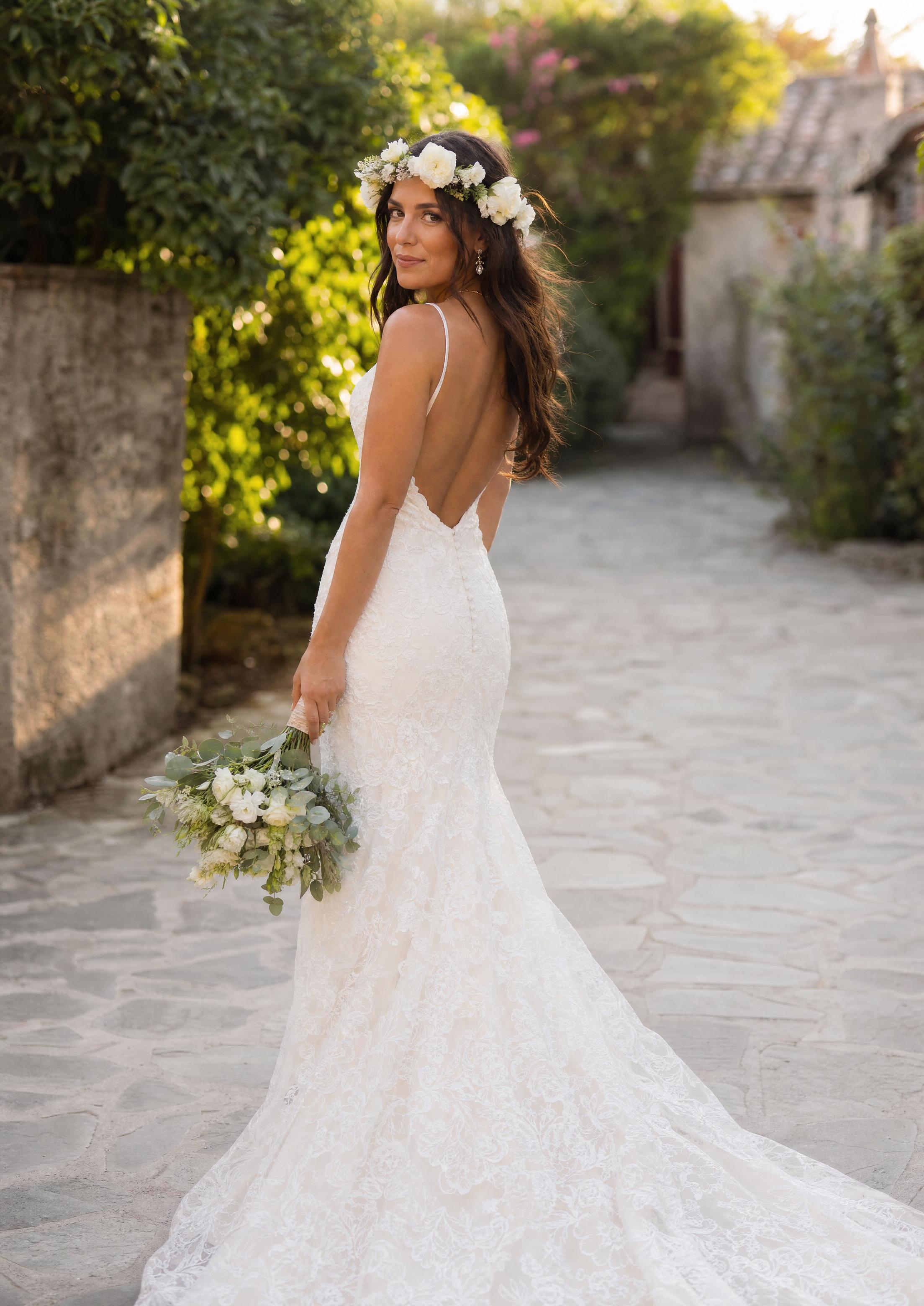 Summer bride styled with a fresh floral headpiece and delicate sparkling jewelry, glowing in natural sunlight